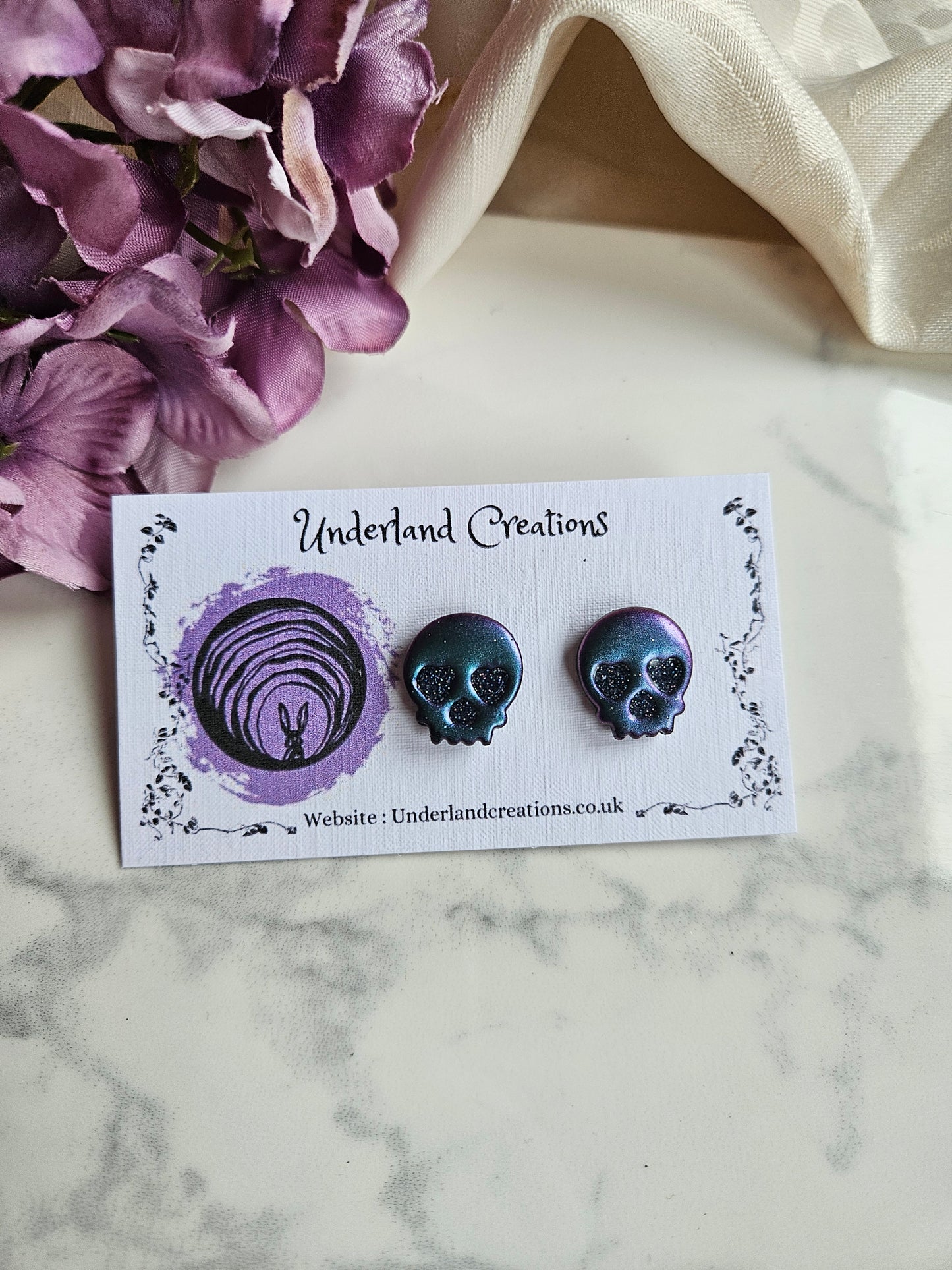 Skull Stud Earrings in Metallic Purple/Blue