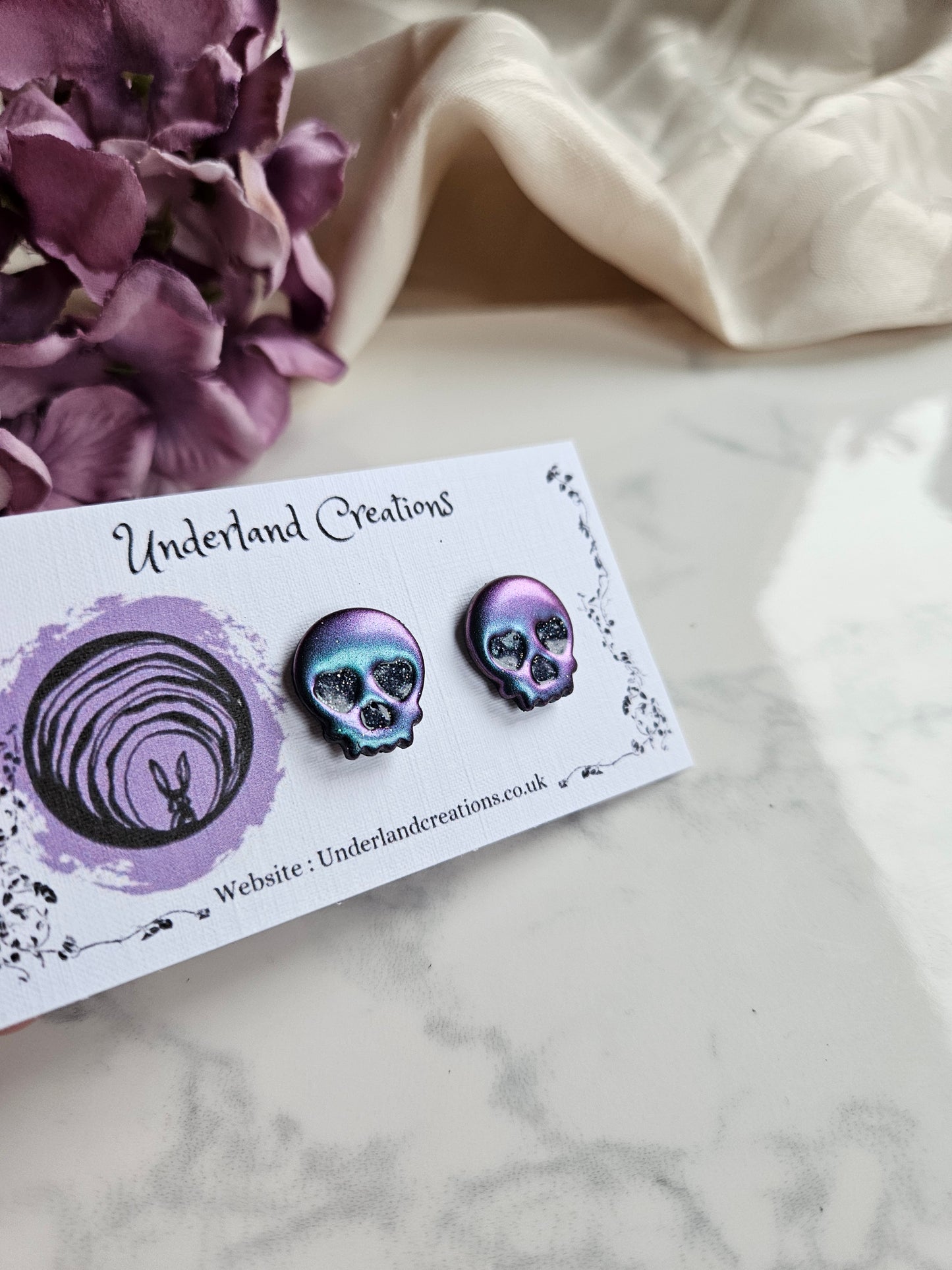 Skull Stud Earrings in Metallic Purple/Blue